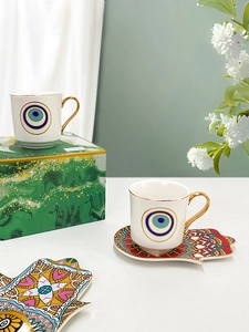 Detail of Turkish coffee cup with Evil Eye motif and Hamsa ceramic tray in a gift box