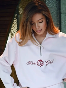 Close-up of pink fleece sweatshirt showing half-zip collar and crown logo embroidery