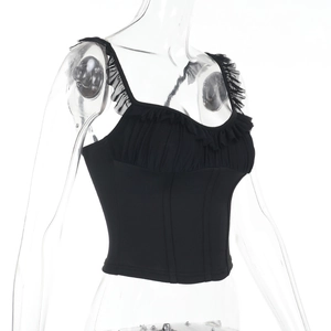 Dettaglio del top a corsetto in mesh nero con orlo a balze e particolari in pizzo