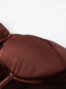 Detailed close-up of brown velvet corset top with satin finish and padded chest design