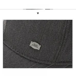 Detailed macro view of dark grey twill baseball cap with metal Jeans Fashion badge