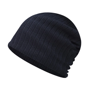 Detailed macro view of dark blue knit beanie showing vertical stripes and cable patterns