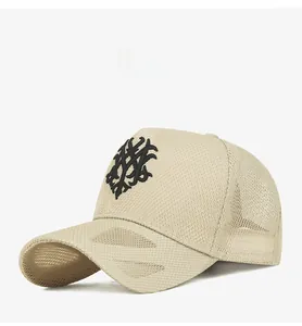 Close-up of beige mesh baseball cap with detailed black embroidered abstract logo