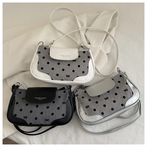Vue détaillée de sacs bandoulière en blanc, noir et argent avec des motifs de nœuds élégants