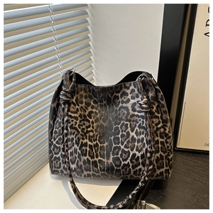 Detail showing the leopard print tote bag with a knotted strap and leather-like texture