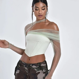 Dettaglio del corsetto bianco con maniche in rete e design strutturato con stecche a lisca