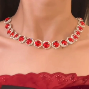 Elegant silver necklace set with round red gemstones worn by a model in red lace