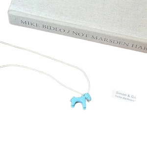 Cute blue pony pendant necklace with glossy enamel finish on a simple white string cord