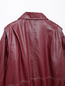 Close-up of burgundy faux leather jacket with contrast white stitching details