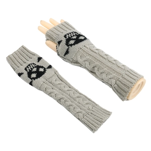 Detail view of grey knit arm warmers with black skull pattern and cable knit texture
