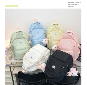 Vue détaillée du tissu gaufré sur sacs à dos scolaires avec pendentifs lapin en peluche