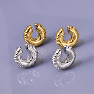 Macro shot of 18k gold and silver donut clip-on earrings with textured hollow surface