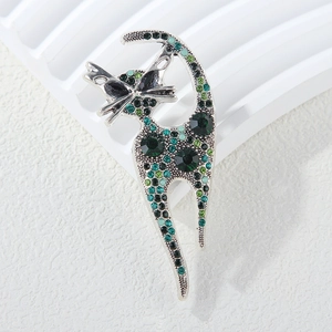 Macro shot of a silver cat brooch featuring sparkling green and black rhinestones