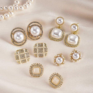 10-piece gold earrings set with pearls and rhinestones on beige satin fabric