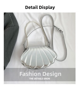 Detail der silbernen Muscheltasche mit Steppmuster und elegantem Perlengriff