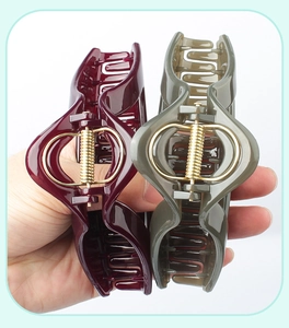 Close-up of elegant burgundy and dark green triangular hair claws with a strong metal spring