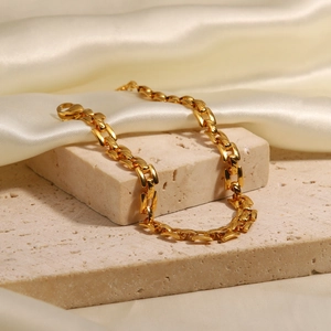 Luxurious 18K gold stainless steel chunky chain bracelet displayed on a stone pedestal