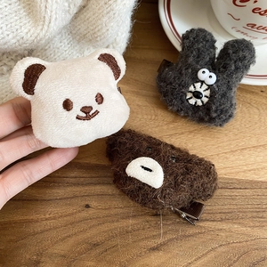 Detailed view of plush bear and rabbit hair clips with soft faux fur and secure metal grip