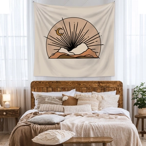 Bohemian wall tapestry with mountain and moon lines hanging above a cozy bed