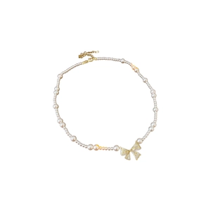 French style gold bow pendant pearl necklace with vintage zircon details on white background