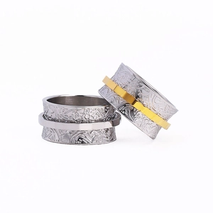 Vintage wide spinner ring with floral relief patterns in silver and gold tones