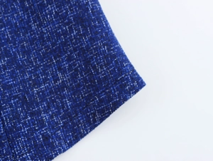 Close-up of dark blue tweed fabric showing detailed woven texture and white fiber specks