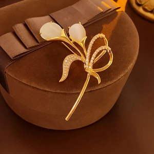 Detailed view of tulip brooch with white opal and small diamonds on brown velvet box