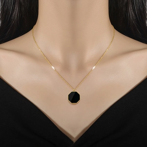 Gold titanium steel necklace with a black hexagonal shell pendant on female model