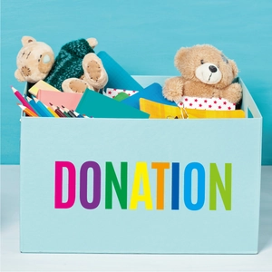 Detail of colorful alphabet stickers on a blue donation box with school supplies