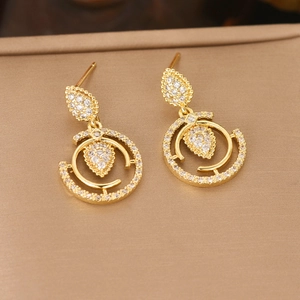 Boucles d'oreilles dorées avec anneaux et zircons sur fond en soie satinée