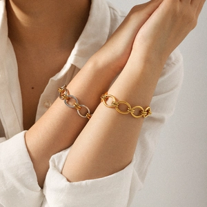 Bracelet chaîne en acier inoxydable bicolore or et argent porté au poignet d'une femme