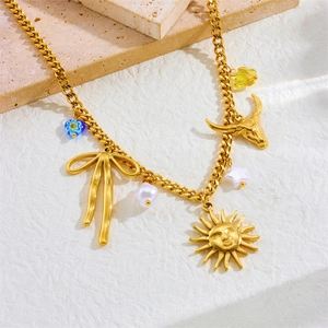 Gold tone stainless steel necklace featuring bow, bull head and sun charms on stone