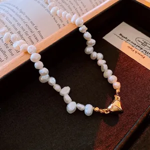 Baroque freshwater pearl necklace featuring a vintage gold heart magnetic clasp pendant