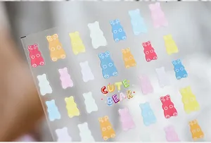 Detailed view of colorful translucent gummy bear nail art stickers with Cute Bear text