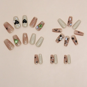 Short ballet press-on nails with heart, star, and moon patterns and green gemstones