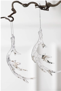 Macro shot of two transparent acrylic antler ornaments with gold and silver glitter inside