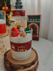 Detailed view of strawberry and gingerbread man decorations on a Christmas soy candle