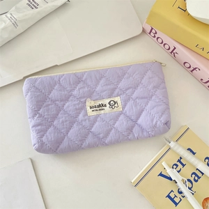Détail de la trousse matelassée violette avec motif en losange et logo sozakka minimaliste