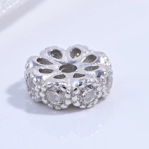 Macro view of flower-shaped silver charm bead with inlaid zircon for DIY jewelry making