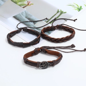 Detail of a 3-piece set featuring a bronze tree of life charm on woven leather bracelets