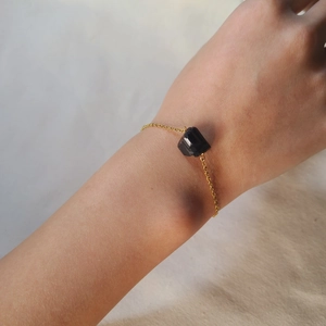 Minimalist gold chain bracelet featuring a natural irregular raw black tourmaline stone