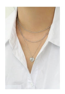 Detail shot of multi-layer silver heart angel pendant necklace on a white shirt