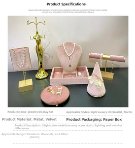Close-up of pink velvet and gold metal jewelry display set for rings and necklaces
