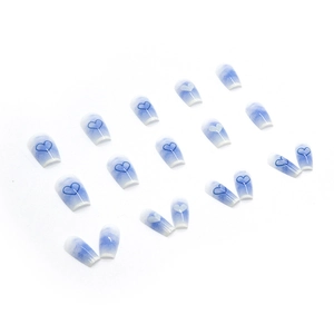 Blue gradient press-on nails with white heart patterns in a medium-long coffin shape