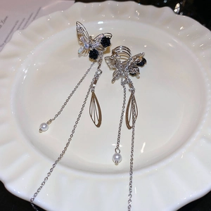 Detail view of silver butterfly tassel earrings with black rose and pearl accents