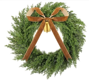 Detail of Christmas wreath with green cedar needles, caramel velvet bow, and gold bell