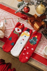 Close-up of cozy coral fleece Christmas socks featuring Santa and snowman patterns