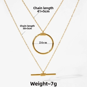 Detailed view of layered gold OT buckle necklace with ring and bar pendants
