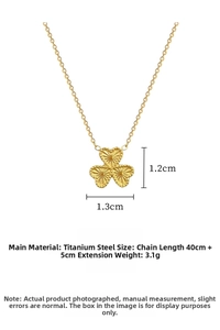 Detailed macro view of golden clover pendant with radial texture and extension chain