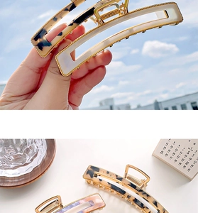 Detail of tortoise shell and pearlescent hair claws with golden metal springs and trim